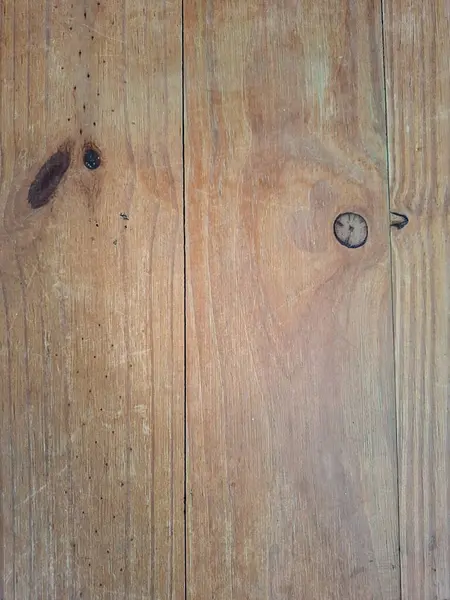 Dikey tahta levhaların yakın plan fotoğrafı belirgin düğümler, belirgin tahıl desenleri, kullanım izleri ve zeminin doğal dokusunu ve yaşlanmış görünümünü vurgulayan küçük çatlaklar..