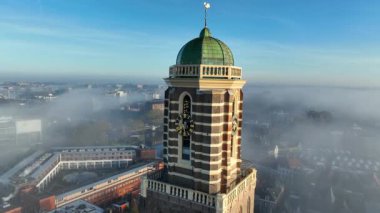 Zwolle Peperbus kilise kulesi, sonbahar gündoğumunda şehir merkezindeki hava aracının sisi üzerinde yükseliyor..