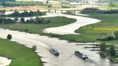 Yük gemileri Ijssel Nehri 'ni Zwolle' un yukarısından görülen bir ilkbahar gününde geçtiler..