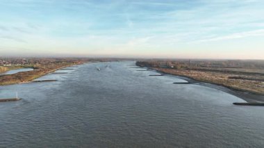 Yük gemisi Nijmegen nehrinde salya akıtıyor. Sonbahar sabahı yukarıdan görüldü..