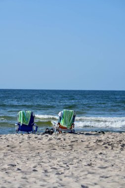 Deniz kıyısındaki plaj manzarası: deniz manzaralı iki katlanabilir sandalye.