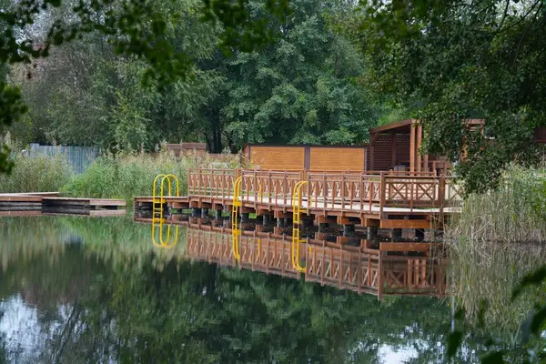 Parmaklıklı ahşap platformla donatılmış resimli göl kıyısı..