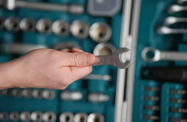 Erkek eli İngiliz anahtarını 18 kalibrelik tutuyor..