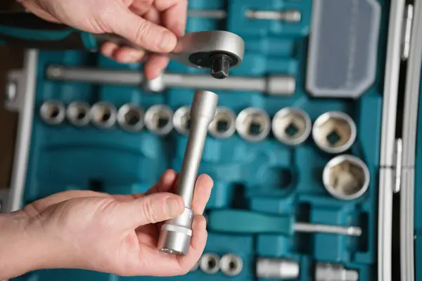 Mandallı anahtar, alet çantasının arka planında erkek eli ile kapanır..