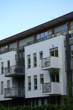 Pencereleri ve balkonları olan modern beyaz binanın dışı.