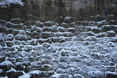 Karla kaplı eski taş duvar ustası..