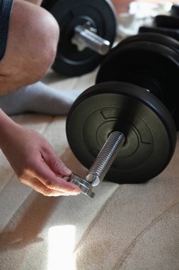 Diskleri güvene almak için yay kilidini kaldıran ya da ayarlayan katlanabilir halter ve el