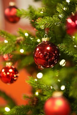 Kırmızı toplar ve LED çelenklerle süslenmiş Noel ağacı