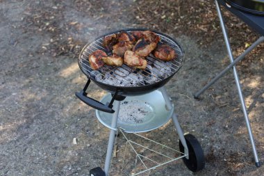 Domuz pirzolası ızgarada pişiyor. Açık havada lezzetli bir yemek sahnesi yaratıyor. Piknik ya da barbekü için mükemmel.