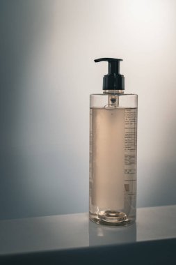 Işık arka planında pompa dağıtıcısı olan minimalist şişe.