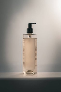 Işık arka planında pompa dağıtıcısı olan minimalist şişe.