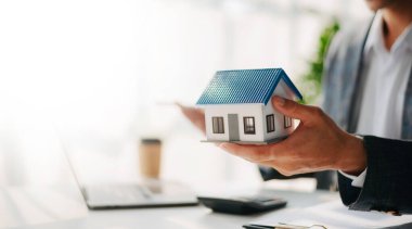 Considering buying a home, investing in real estate. Broker signs a sales agreement. agent, lease agreement, successful deal in office