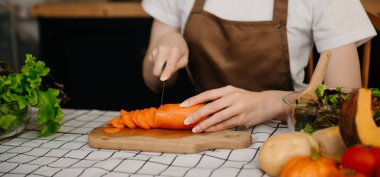 Genç Kadın 'ın yemek pişirme videosu mutfakta görüntülü konuşma yapıyor. Gülümseyen mutlu bir kadın arkadaşla konuşuyor.