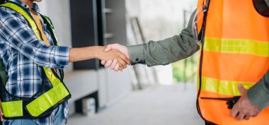 İnşaat ekibi, inşaat projeleriyle ilgili danışmanlık yapmak için ofis merkezindeki sarı miğferin arkasında yeni proje planını başlatın.