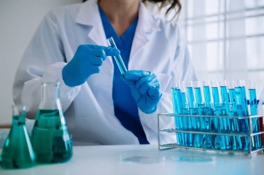 Coronavirus COVID-19 aşısını laboratuvar çalışmalarında tutan ve bilimsel örnekleri analiz eden sağlık uzmanı.