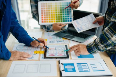  UX geliştiricisi ve ui tasarımcısı ofisteki müşteri breif ve renk kodu ile mobil uygulama arayüzü kablo tasarımı hakkında beyin fırtınası yapıyor