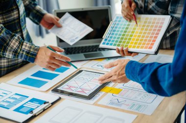  UX geliştiricisi ve ui tasarımcısı ofisteki müşteri breif ve renk kodu ile mobil uygulama arayüzü kablo tasarımı hakkında beyin fırtınası yapıyor