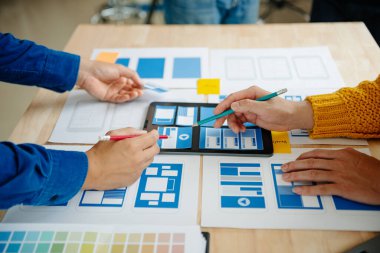 UI müteahhitlerinin projelerini dizüstü bilgisayar, akıllı telefon ve dijital tablet ile beyin fırtınası yaparken görüntülerini kapatın. Yaratıcı dijital geliştirme ajansı