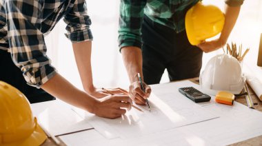 Çalışma ve tablet hakkında konuşan iki meslektaş, ofisteki inşaat alanında mimari projeyle ilgili bilgisayarı açtılar.