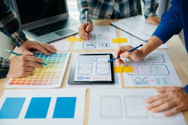  UX geliştiricisi ve ui tasarımcısı ofisteki müşteri breif ve renk kodu ile mobil uygulama arayüzü kablo tasarımı hakkında beyin fırtınası yapıyor