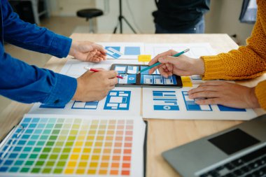 UI müteahhitlerinin projelerini dizüstü bilgisayar, akıllı telefon ve dijital tablet ile beyin fırtınası yaparken görüntülerini kapatın. Yaratıcı dijital geliştirme ajansı