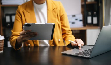 İş adamı dijital tablet bilgisayar ve akıllı telefon ile çalışıyor. Finansal iş stratejisi katmanı etkisi sabah güneşinde masada.