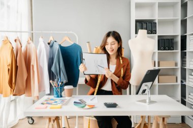 Boyunlarında santimetre boyayla çalışan ve tablet ve akıllı telefon tutan çeşitli kadın moda tasarımcıları. bağımsız yaratıcı tasarım işi. 