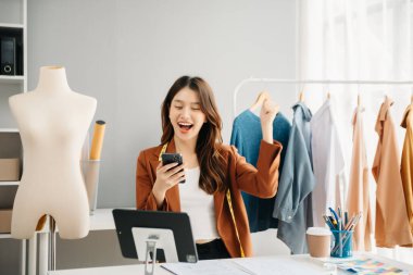 Boyunlarında santimetre boyayla çalışan ve tablet ve akıllı telefon tutan çeşitli kadın moda tasarımcıları. bağımsız yaratıcı tasarım işi. 