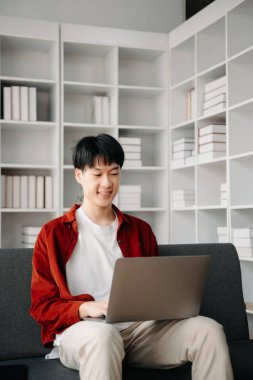 Modern ofiste masasında oturan Asyalı genç bir adamın portresi..