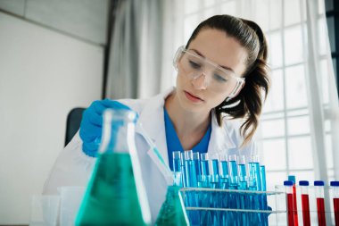 Modern tıbbi araştırma laboratuvarı. Kadın bilim adamı mikro pipetlerle çalışıyor biyokimyasal örnekleri analiz ediyor, ileri bilim kimya laboratuvarı