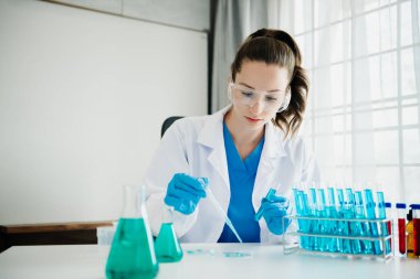 Modern tıbbi araştırma laboratuvarı. Kadın bilim adamı mikro pipetlerle çalışıyor biyokimyasal örnekleri analiz ediyor, ileri bilim kimya laboratuvarı