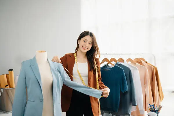 Boyunlarında santimetre boyayla çalışan ve tablet ve akıllı telefon tutan çeşitli kadın moda tasarımcıları. bağımsız yaratıcı tasarım işi. 