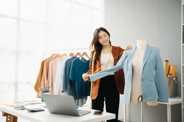 Boyunlarında santimetre boyayla çalışan ve tablet ve akıllı telefon tutan çeşitli kadın moda tasarımcıları. bağımsız yaratıcı tasarım işi. 