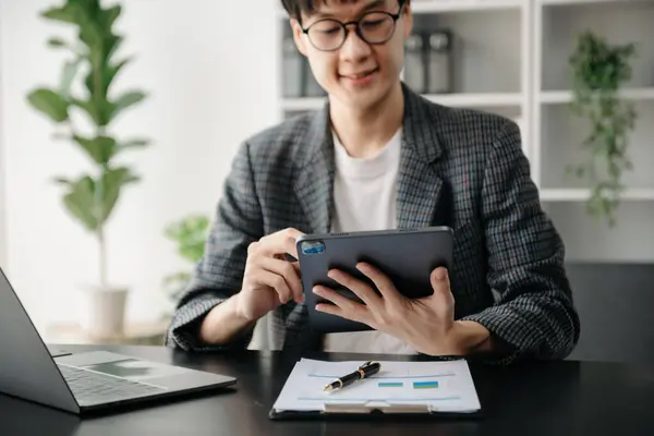 İş adamının elleri akıllı telefon, tablet ve dizüstü bilgisayarı, klavye bilgisayarını, daktiloyu, modern ofiste online olarak daktilo ediyor.