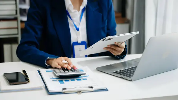 İş kadını dijital tablet bilgisayarla çalışıyor ve akıllı telefon ile finans sektörü stratejisi katmanı sabah ışığı üzerinde.