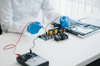 Elektronik teknisyen, elektronik mühendisliği, elektronik onarım, ölçüm ve test, onarım ve bakım kavramları. Kontrol ve yükseltme için voltaj ölçer kullanır 