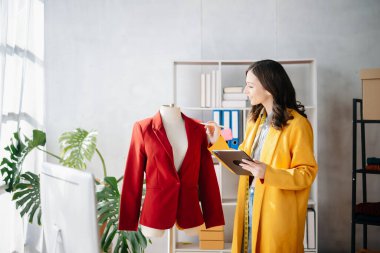 Boyunlarında santimetre boyayla çalışan ve tablet ve akıllı telefon tutan çeşitli kadın moda tasarımcıları. bağımsız yaratıcı tasarım işi.