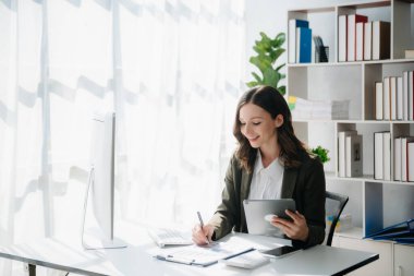 Serbest çalışan kadın bilgisayar tableti ve dizüstü bilgisayarı üzerinde çalışıyor. Muhasebe analizi yapıyor. Emlak yatırım verileri, modern ofis finansmanı.