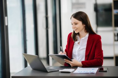 Kadın ofis çalışanı portresi, ofis masasındaki dizüstü bilgisayarla yaptığı iş, başlangıç ve çalışma hakkında hayal kuruyor.