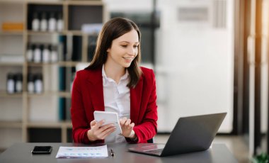 Kadın ofis çalışanı portresi, ofis masasındaki dizüstü bilgisayarla yaptığı iş, başlangıç ve çalışma hakkında hayal kuruyor.