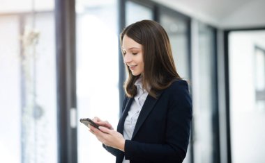 Çalışan kadın konsepti video konferansına katılan bir bayan yönetici ve elinde tablet, ofisinde smatrphone.
