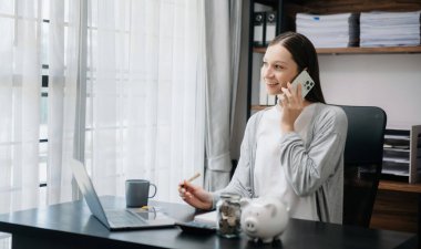 Serbest çalışan kadın bilgisayar tableti ve dizüstü bilgisayarı üzerinde çalışıyor. Muhasebe analizi yapıyor. Gayrimenkul yatırım verileri, finansal... 