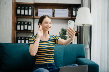 Ofiste çalışan Kafkas iş kadını. Not defteri, tablet ve dizüstü bilgisayarla. İç işlerindeki kanepede.