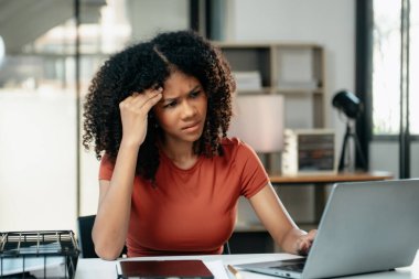 İş kadını, modern ofiste tablet üzerinde çalıştığı için stresli, sıkılmış ve aşırı düşünüyor.