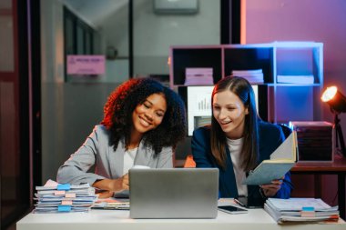İş kadını takım toplantısını yönetiyor ve birlikte çalışma ofisinde mali durumu iyi olan tablet ve dizüstü bilgisayar kullanıyor. overtim