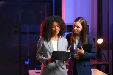 Akıllı telefondan konuşan ve ofiste dizüstü bilgisayar kullanan iki iş adamı. overtim