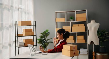 Çevrimiçi mağaza işleten genç Afrikalı kadın akıllı telefon ya da tablet kullanarak küçük işletme KOBİ 'si başlatarak, evdeki çevrimiçi alışveriş siparişlerini alıp kontrol ediyor