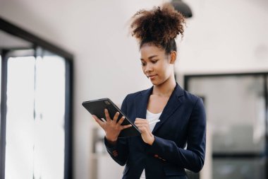 Ofisteki kameraya gülümseyen genç ve çekici Afrikalı ofis çalışanı takım elbiseler. 