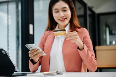 İş kadını eli akıllı telefon, tablet ödemeler ve kredi kartı online alışveriş, omni kanal, ofiste dijital tablet bilgisayar kullanıyor.