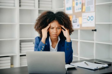 Ofis masasında uzun bir gün geçirdikten sonra boynu ağrıyan genç Afrikalı iş kadını. Ofis sendromu.